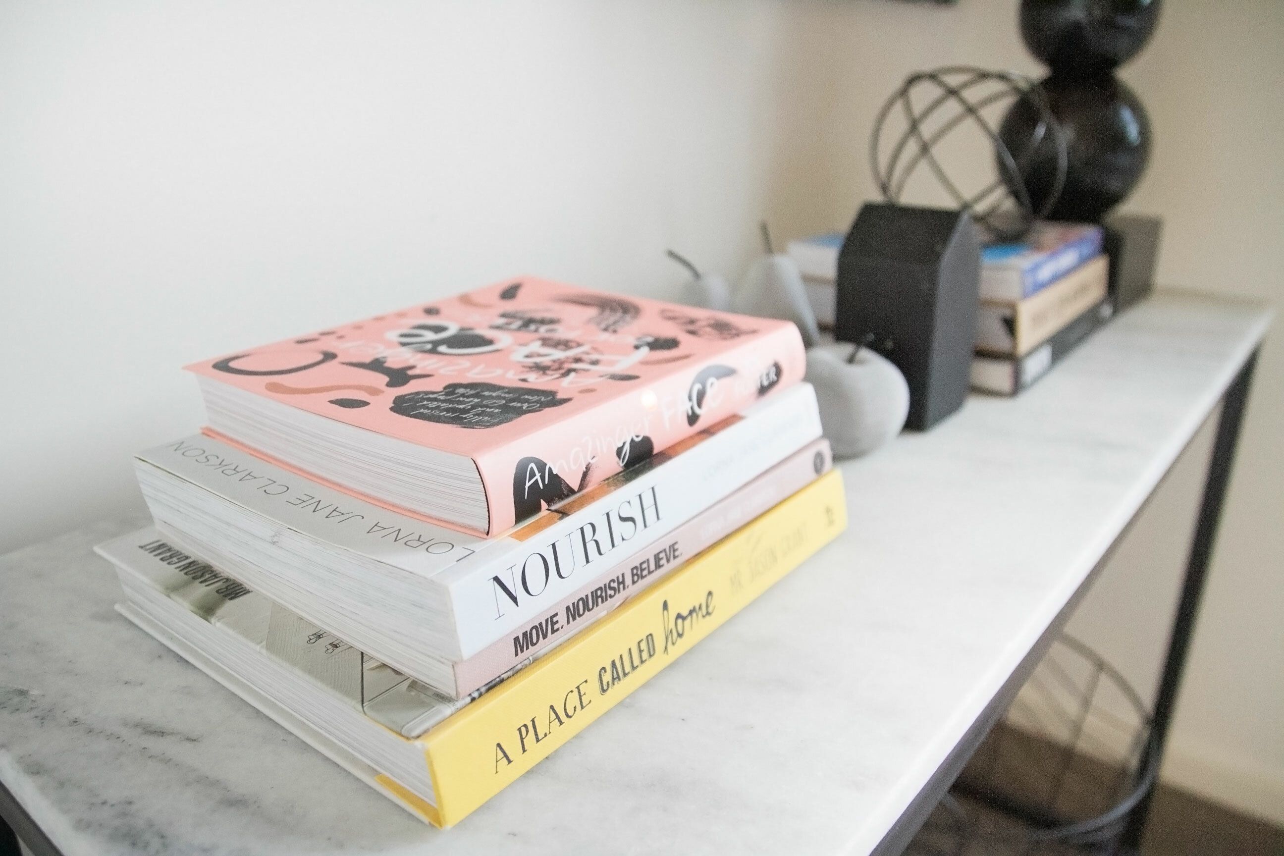 A stack of books on a white table.