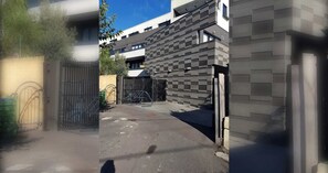 A gated entrance with a metal gate, a paved driveway, and a building with a modern architectural style. - Charming 2BDR Apartment in Richmond close to MCG (Richmond)