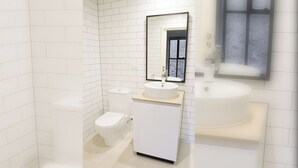 Une salle de bain moderne avec des carreaux blancs, des toilettes, un lavabo et un miroir.