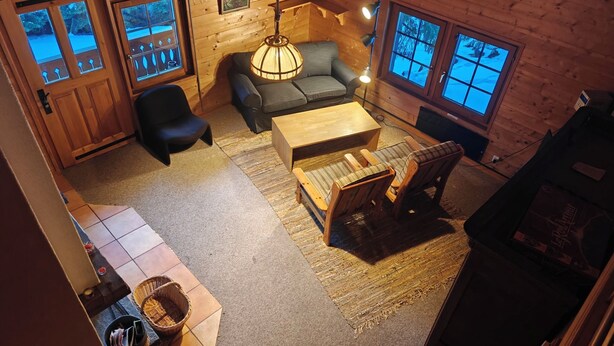 A cozy cabin interior with a sofa, chairs, a wooden coffee table, and a rug. - Chalet Carmazin, (Morgins), by Interhome (Morgins)