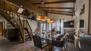 A spacious dining area with a wooden staircase, a modern kitchen, and a large window providing natural light. - Haus Venus, (Zermatt), by Interhome (Zermatt)