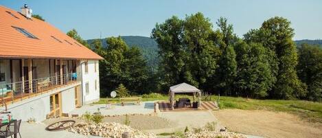 A house with a covered patio, a swimming pool, and a stone pathway.