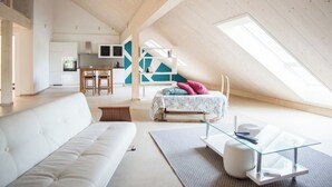 A spacious loft with a high ceiling, a dining area, and a cozy seating area with a bed. - Appartements - Ferme La Joux-Chaupe, (St-Ursanne), by Interhome (Saint-Ursanne)