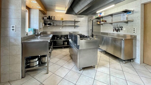 Una cocina moderna con electrodomésticos de acero inoxidable, una isla central y una campana extractora.