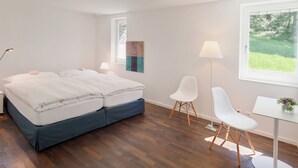 A modern bedroom with a bed, bedside lamps, a desk, and a chair. - Chalet Altesse, (Zermatt), 1054.01 by Interhome (Zermatt)