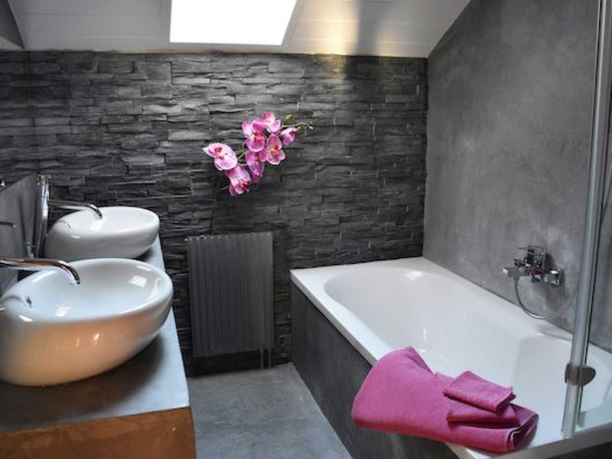 Une salle de bain moderne avec deux lavabos, une baignoire et une douche.