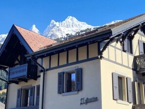 Ein Gebäude mit einem Schild, auf dem 'Eghlin' steht, und einem Berg im Hintergrund.