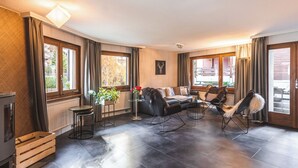 A modern living room with a sofa, chairs, a coffee table, and a fireplace. - Haus Venus, (Zermatt), by Interhome (Zermatt)