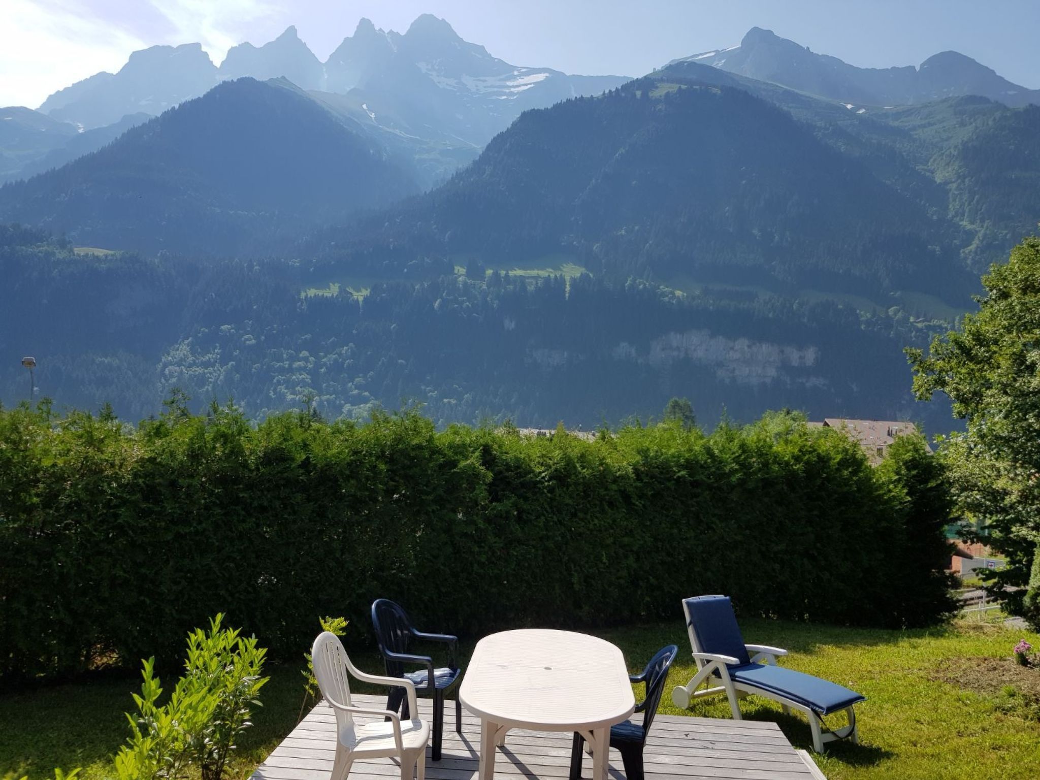 A patio with outdoor furniture overlooking a mountainous landscape.