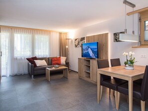 Un salon moderne comprenant un canapé, une table basse, un téléviseur et un coin repas.