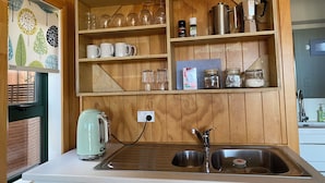 Cuina amb armaris de fusta, un búl, una cafetera i un rentapeus.