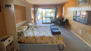 A room with a bed, a desk, a chair, a window, and a door.
