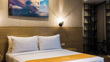 Una habitación de hotel moderna con una cama grande, un cuadro en la pared y una estantería.