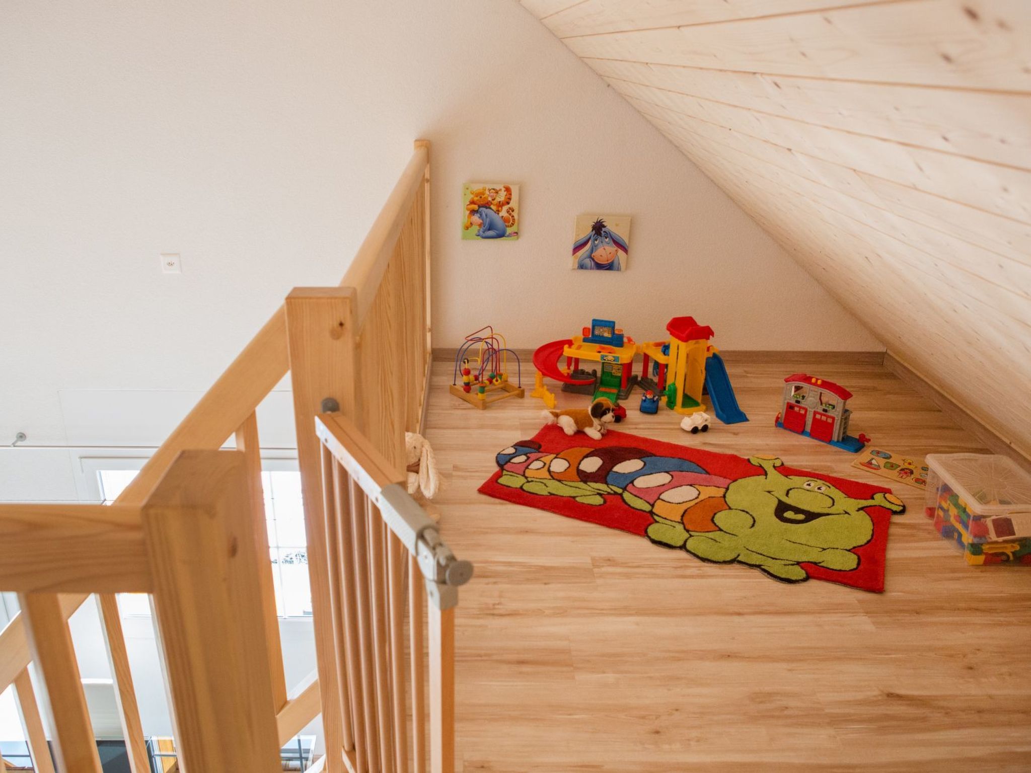 A children's play area with toys and a mat featuring a cartoon character.
