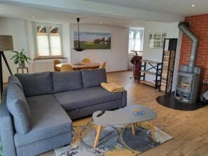 A modern living room with a grey sofa, a small coffee table, and a fireplace. - Appartement - Le Pèlerin, (Saignelegier), by Interhome (Saignelegier)