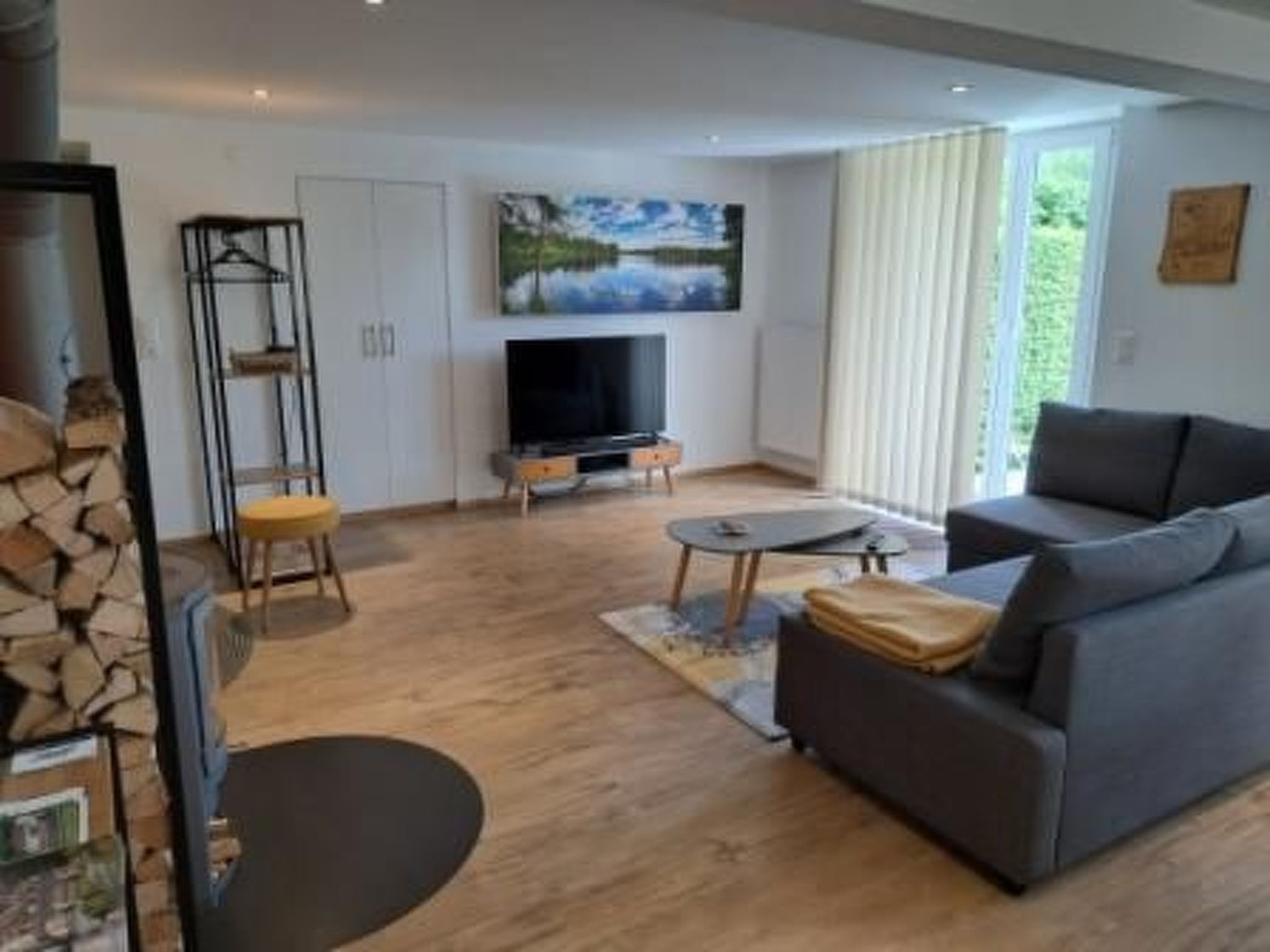 A modern living room with a sofa, a TV, and a fireplace.