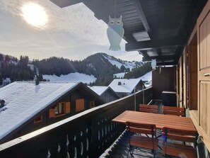 A wooden balcony with a view of snow-covered roofs and mountains. - Oeillet 4, (Champoussin), by Interhome (Les Crosets)