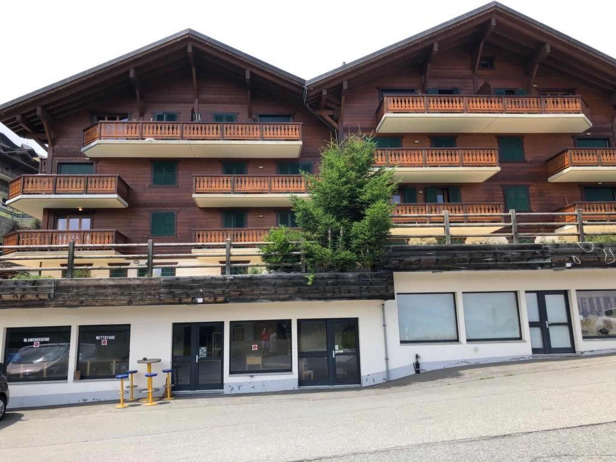 A multi-story building with balconies and a ground-level entrance.
