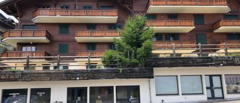 A multi-story building with balconies and a ground-level entrance.