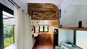 Una cocina compacta con detalles de madera, un área de comedor con banco y vistas al exterior.