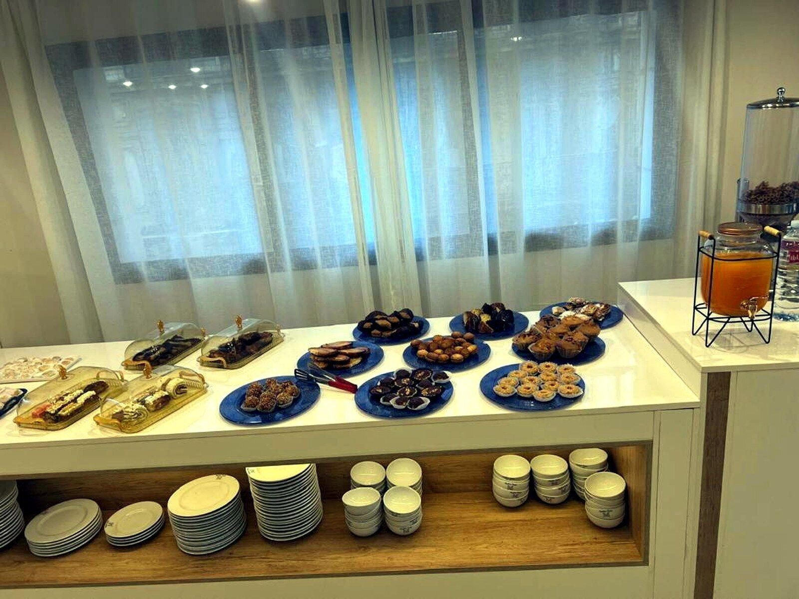 A buffet with various food items and a beverage station.