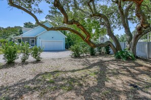 A house with a garage, surrounded by trees and a gravel driveway. - Short Walk to the Beach, Screened Porch, Renovated Home, 4 miles to Downtown, $300 in Free Tickets! (St. Augustine)