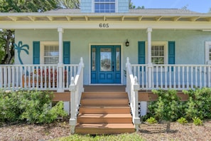 A two-story house with a blue front door, white railings, and a number '605' above the entrance. - Short Walk to the Beach, Screened Porch, Renovated Home, 4 miles to Downtown, $300 in Free Tickets! (St. Augustine)