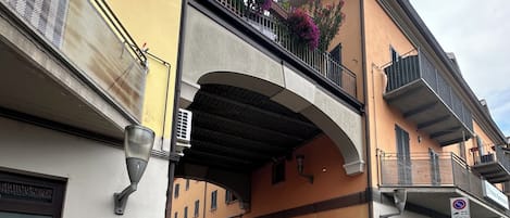 Vista de la calle con un edificio que cuenta con una galería techada, separadores y un cartel que indica zona de no estacionamiento.