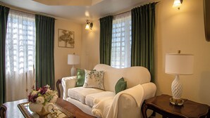 Ein Wohnzimmer mit einer Couch, einem Tisch mit Blumen und einer Lampe.