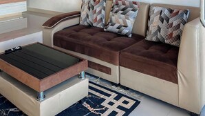 Una sala de estar moderna con un sofá, cojines estampados, una mesita de centro y techo de madera.