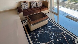 Una sala moderna con sofá, mesa de centro y vistas al exterior.