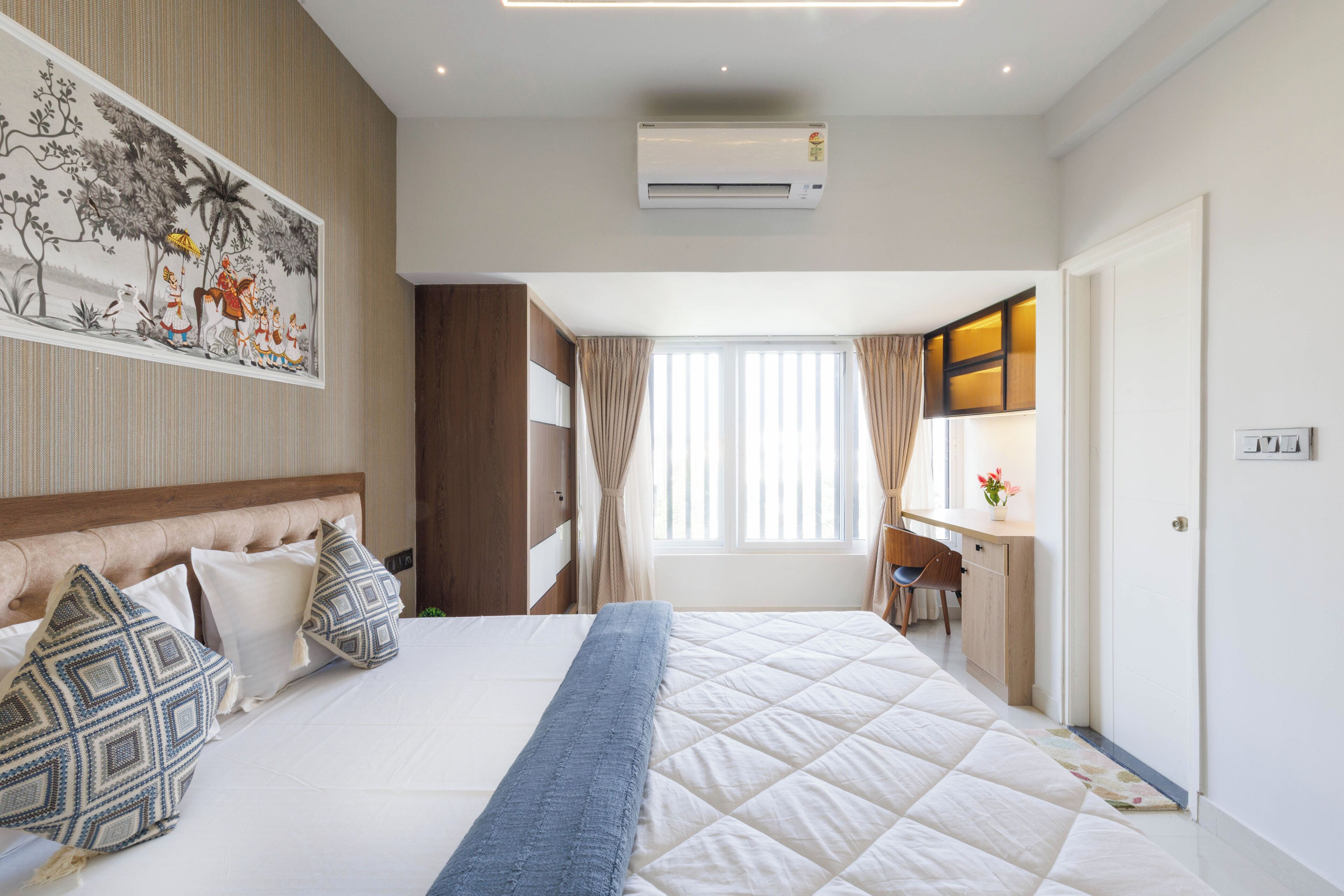 Une chambre d’hôtel avec un lit, un bureau, un climatiseur et un tableau au mur.