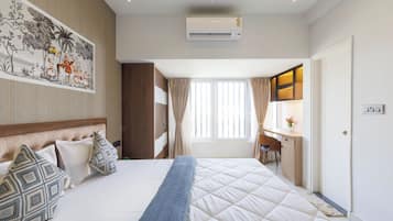 Une chambre d’hôtel avec un lit, un bureau, un climatiseur et un tableau au mur.