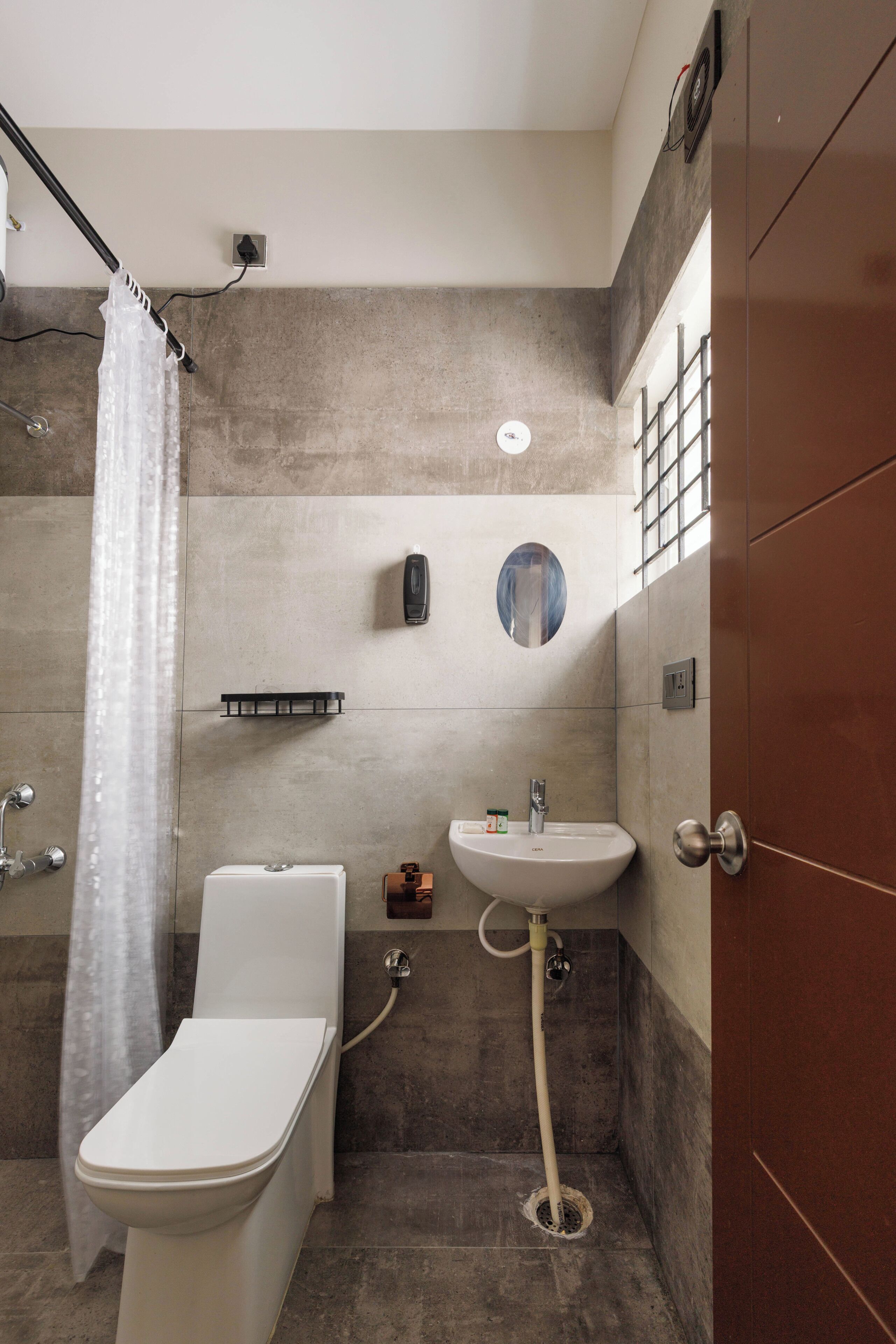 A modern bathroom with a shower, toilet, and sink.