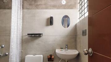 A modern bathroom with a shower, toilet, and sink.