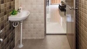 A bathroom with a sink, mirror, and shower. - Jhilmil Escape Pool Garden 1hr Koramangala HSR (Hosur)