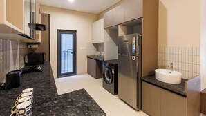 Une cuisine moderne équipée d’un lave-linge, d’un réfrigérateur et d’un évier.