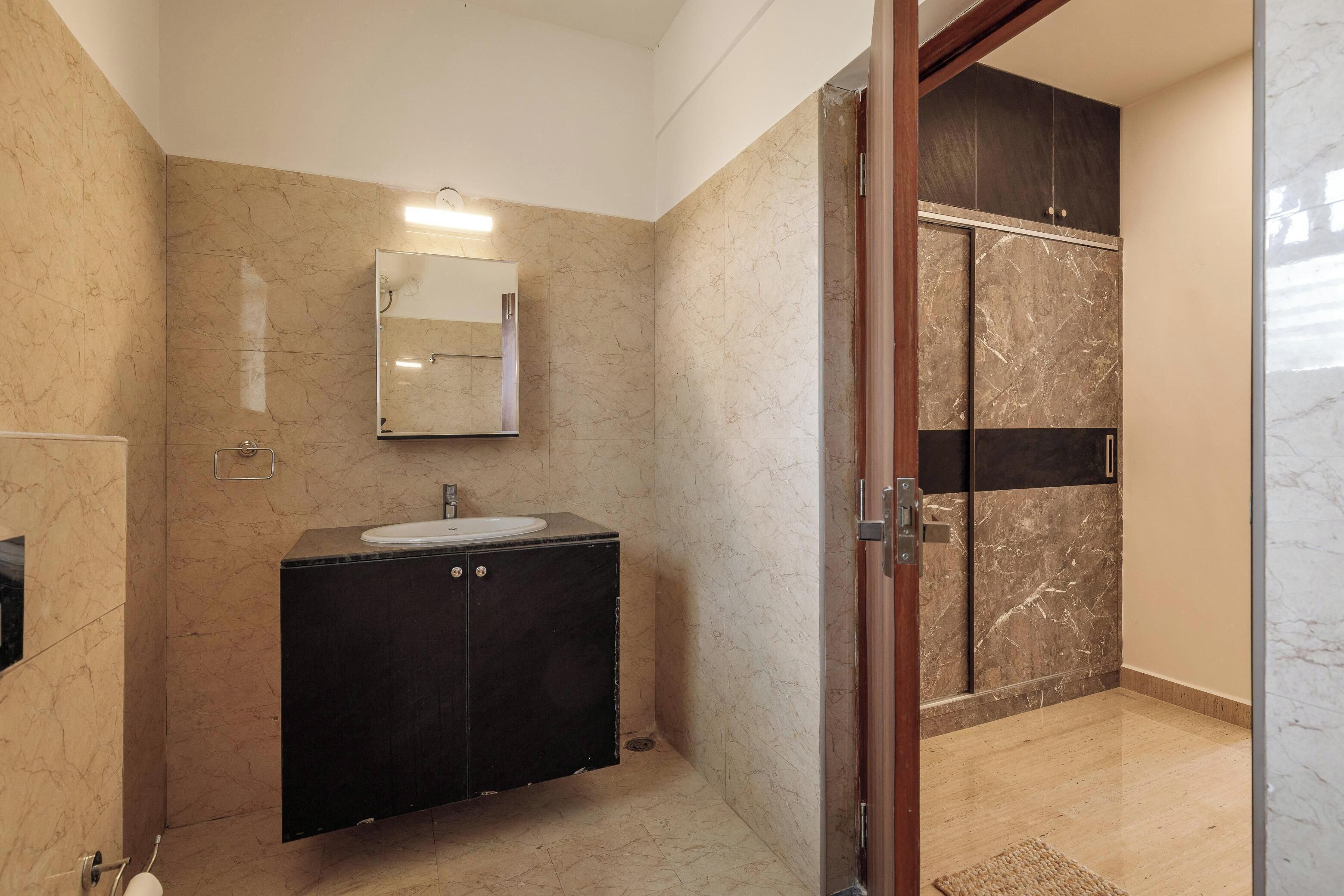 A bathroom with a sink, mirror, and dark cabinets.