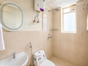 Ein Badezimmer mit Toilette, Bidet, Waschbecken, Spiegel, Dusche und einem Fenster.