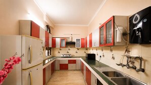 Eine Küche mit Kühlschrank, Herd, Spüle und Wasserspender.