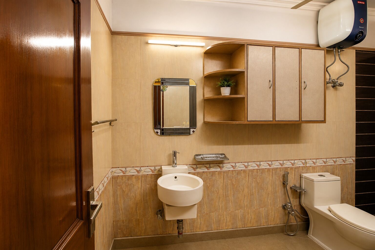 Un bagno con porta in legno, un lavandino, un water, uno specchio e un armadietto.