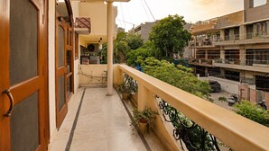 Ein Balkon mit Blick auf umliegende Gebäude und Bäume.