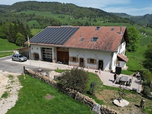 Ein zweistöckiges Haus mit rotem Ziegeldach, einer Garage und einer Solaranlage.