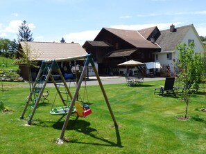 Ein Wohngebiet mit Schaukel, Rasen und einem Haus mit Ziegeldach.