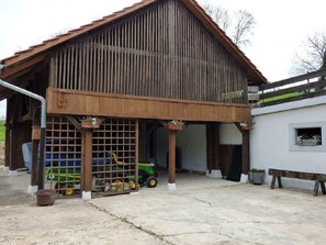 A barn with a slanted roof, a covered entrance, and a concrete floor. - Studio - Le Râtelier, (Coeuve), by Interhome (Coeuve)