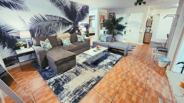 Ein Wohnzimmer mit einer Couch, einem Couchtisch und einer großen Wandmalerei.