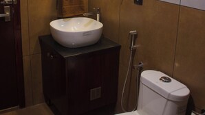 A bathroom with a white sink, a toilet, a towel rack, and a hairdryer. - SURYAMANGALAM HERITAGE (Ottapalam)