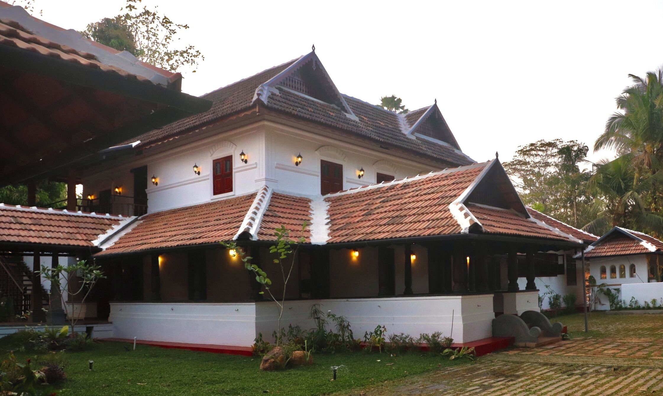 A traditional building with a tiled roof, a staircase, and a well-maintained garden.