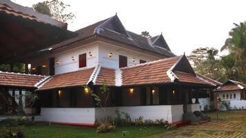 A traditional building with a tiled roof, a staircase, and a well-maintained garden.