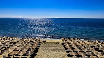 En la playa, arena blanca, sombrillas, bar en la playa